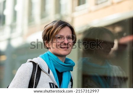 Similar – lachende Frau vor Wand mit Blick nach oben