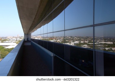 Mirrored Reflection Of Coastal Urban City Landscape On Glass Facade On Balcony Of Commercial Office Block Building In Durban, South Africa