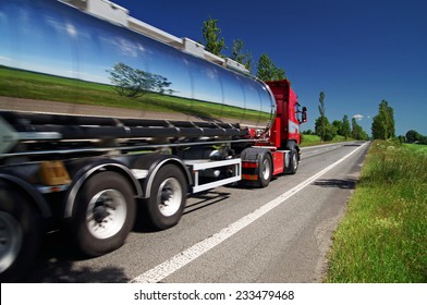 Mirroring the landscape chrome tank truck moving on a highway, view from eye level