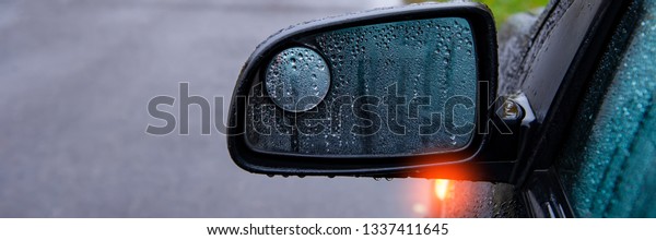mirrors and\
glass and the car in the rain covered with drops of water in the\
meadow and asphalt road. Web\
banner.