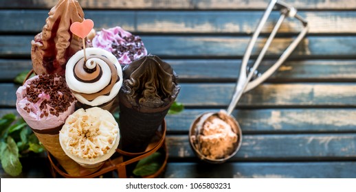 Miscellaneous ice cream cone in a stand on a stylish wooden background, the concept of ice cream and summer