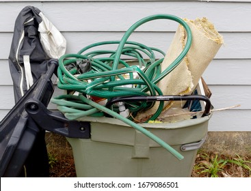 Miscellaneous Spring Cleaning Items Tossed Into Neighborhood Trash Can.