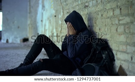 Miserable teenager crying in abandoned house, life destroyed by war, sorrow