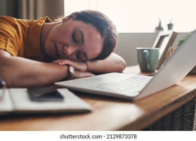 I missed the offramp to my bed. Shot of a young woman sleeping at her desk while working from home.