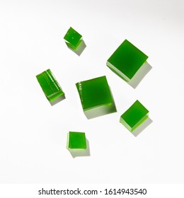 Misshapen pieces of green jelly, isolated on a white background