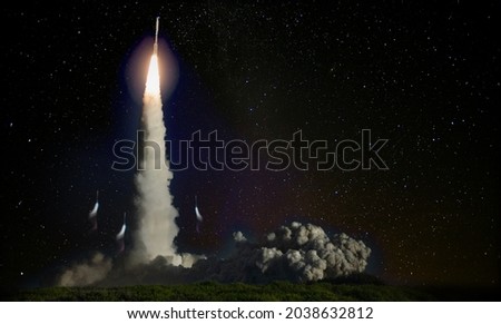 Missile launch at night. Elements of this image furnished by NASA.