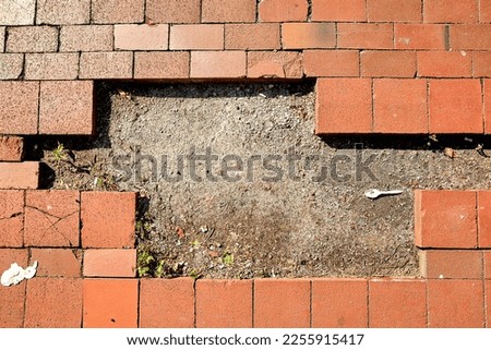 Missing Bricks in Sidewalk with Dirt and Plastic Spoon