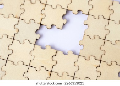 Missing heart-shaped puzzles. A background of puzzles with a white empty space.
