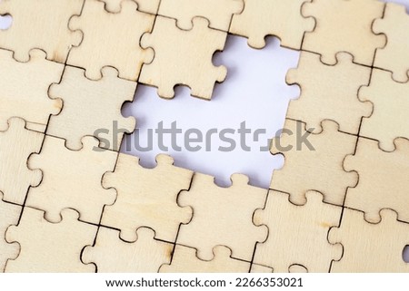 Missing heart-shaped puzzles. A background of puzzles with a white empty space.