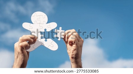 Missing jigsaw puzzle piece human team employee or health and wellbeing personal fulfilment concept against blue sky background