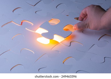 Missing jigsaw puzzle piece with light glow, business concept for completing the final puzzle piece