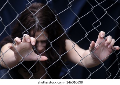 A missing kidnapped, abused, hostage, victim girl alone in emotional stress and pain, afraid, restricted, trapped, call for help, struggle, terrified, threaten, locked in a cage cell try to escape.