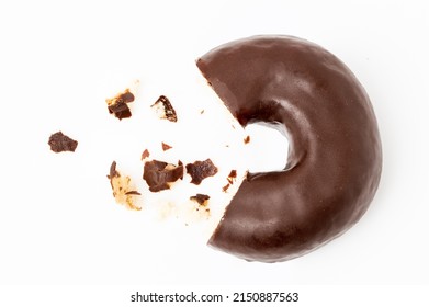 Missing piece of chocolate donut with crumbs on white background.