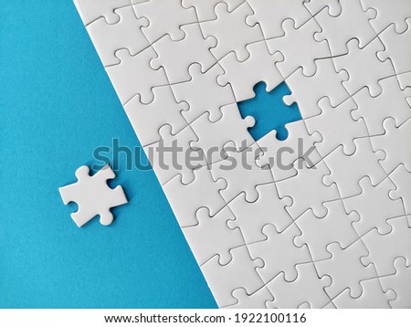 Missing piece of the puzzle, white puzzle pieces on blue background