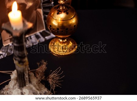 Missing you, remembering loved ones gone. Lit candle with incense burner infant of picture of a love one, against dark background