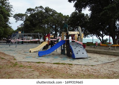 Mission Bay, Auckland / New Zealand - March 27 2020: Police Emergency Red And White Warning Tape On Children's Outdoor Playground  Equipment To Prevent Use During The Coronavirus Lockdown.