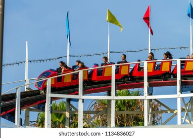 MISSION BAY, CA-USA-11 JULY 2018- People Ride Giant Dipper Roller Coaster At Belmont Park. Sideview Shows Wheels And Flags. The Mission Beach Roller Coaster, Wooden Built In 1925 By Prior And Church. 