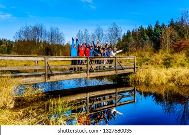 Mission, British Columbia/ Canada: Nov. 12, 2018: Three Generations Of A Family  Cheering On A Bridge On The Hiking Trails Of Silverdale Creek Wetlands, A Freshwater Marsh And Bog Near Mission, BC