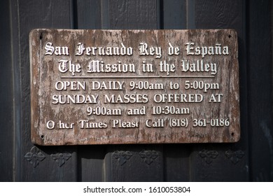 Mission Hills, California / USA -  January 7, 2020: Entry Admissions And Mass Services Hours Sign At The Historical Spanish Mission San Fernando Rey De España.