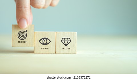 Mission, vision and values of company. Purpose business concept. Hand holds wooden cube with mission symbol and vision, values symbols on grey background. Modern flat design. Business presentation. - Shutterstock ID 2135373271