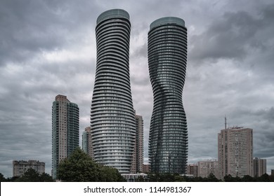 MISSISAUGA, CANADA - JULY 28, 2018: Absolute World Towers or Marilyn Monroe Towers - skyscrapers condominium complex, and the nearby buildings on a cloudy sky background in a rain