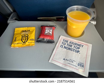 MISSOULA, MT, MAY 2021: Airline Snacks And Orange Juice Served On A Delta Airlines Flight, On Pull Down Seat Table