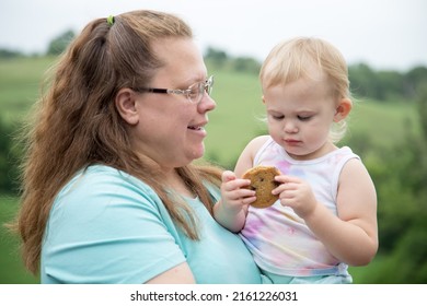 Missouri Valley, Iowa United States June 18, 2020 An Aunt Loving Her Niece And Young Toddler Girl Eating A Chocolate Chip Cookie