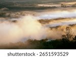 Mist is lit up by sunrise light over the Wisconsin River valley from Wyalusing State Park, Grant County, Wisconsin