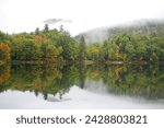 Mist rising over hills and autumn foliage around the woodward reservoir in central vermont, new england, united states of america, north america