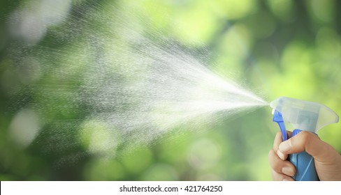 The Mist Spray Bottle To Spray Water Into The Air. Background Bokeh Leaves