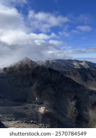 A mist-covered mountain peak with a dramatic cloudy sky