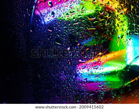 Misted glass, colorful abstract rainbow colored mist rain drops dew drops water droplets condensation on rainbow tinted glass window