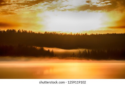 Misty Calm Evening On The Forest Lake Is Illuminated By The Colors Of Sunset, Melting Ice, Reflection In The Water Mirror. Spring In The Arctic North. Scandinavia, Lapland