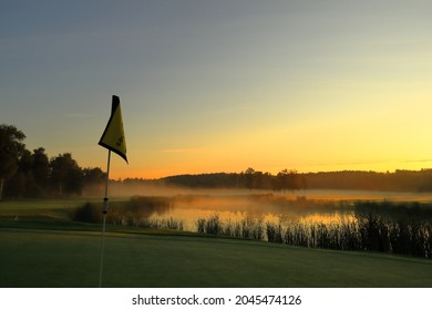 Misty landscape in the early morning at a golf course. Single golf flag. Sun rising in the east. Next to a small lake. Vallentuna, Stockholm, Sweden, Scandinavia, Europe. - Powered by Shutterstock