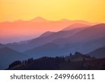 Misty layers of mountains and silhouettes ridgelines going into the distance under the evening sunlight. Location place Carpathian National Park, Ukraine, Europe. Photo wallpaper. Beauty of earth.