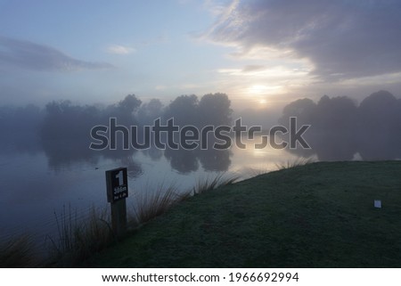 Misty Morning Landscape with Golf Course Marker
