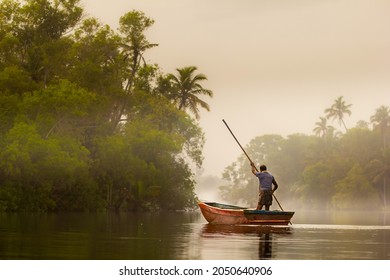 Misty morning and a man, fisherman on the boat on ethe river with 