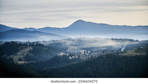 Misty mountain landscape at dawn, with layers of dark green forests and rolling hills. Small rural homes and communication tower scattered across hillsides. Distant mountains bathed in soft light. - Powered by Shutterstock