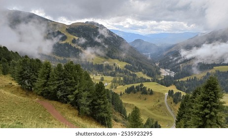 A misty mountain landscape with green valleys, dense pine forests, and winding paths. Clouds hover around the peaks, creating a serene and atmospheric alpine view. - Powered by Shutterstock