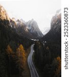 Misty mountain pass in the Dolomites. Forest car road in across hills, mountain hill in nature photography, mountain range landscape scenery photo in nature.