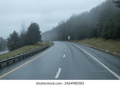 Misty Mountain Road with Fresh Wet Pavement Winding Through a Forested Landscape. - Powered by Shutterstock