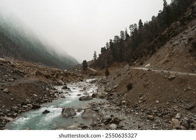 A misty mountain valley with a turquoise stream flowing through rugged terrain, surrounded by dense forests and rocky slopes, evoking a sense of tranquility and adventure. - Powered by Shutterstock