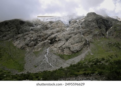 Misty Mountain Waterfall in a Rocky Landscape with Green Vegetation - Powered by Shutterstock