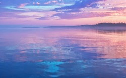 Misty Seascape - Calm Water Surface Of The Lake Reflects Lilac Sky With Pink And Blue Clouds After Sunset. White Nights Season In The Republic Of Karelia, Russia. Blur Filter, Space For Copy.