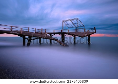 misty sunset and broken pier bridge in blue hour