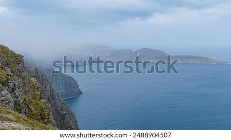 A misty view from the clifftops overlooking the dramatic coastline of Northern Norway. Nordkap or North Cape