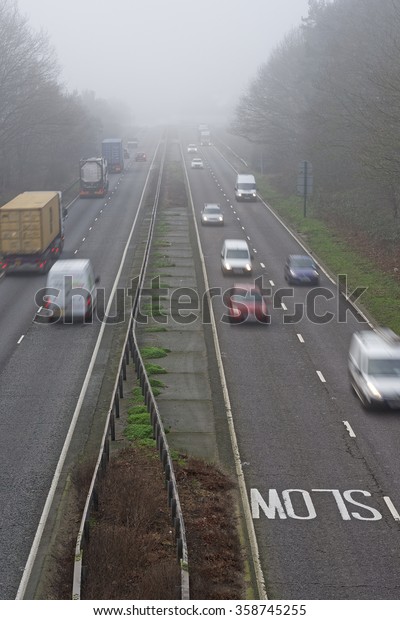 Misty winter morning on a busy road in the\
UK. All logos blurred and\
unreadable.