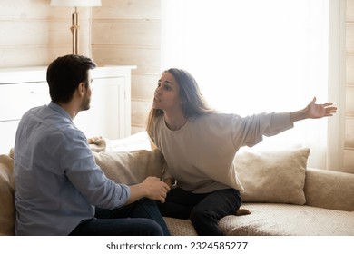 Misunderstanding. Angry worried young spouses quarreling arguing at home, annoyed nervous millennial wife shouting screaming on frustrated husband accusing in cheat threatening with breakup divorce