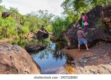 Mitchell Plateau, WA, Australia - May 31, 2015: An Indigenous Australian Man And Child From The Local Kandiwal Community Accompanied A European Man Climb Over Rocks At  A Prisitne Outback River.