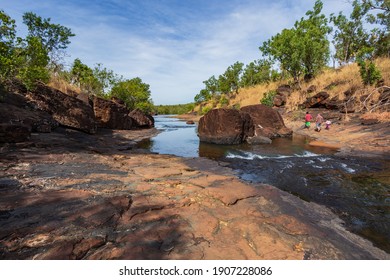 Mitchell Plateau, WA, Australia - May 31, 2015: An Indigenous Australian Man And Child From The Local Kandiwal Community Accompanied A European Man Climb Over Rocks At  A Prisitne Outback River.